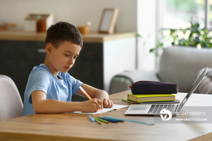 Little boy studying online at home