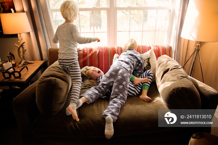 Siblings playing on sofa