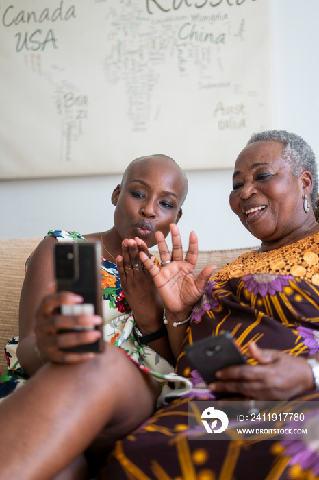 微笑的女人和妈妈在家用智能手机视频通话