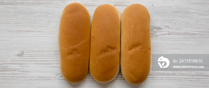 Fresh hot dog buns on a white wooden background, top view. Flat lay, from above, overhead.