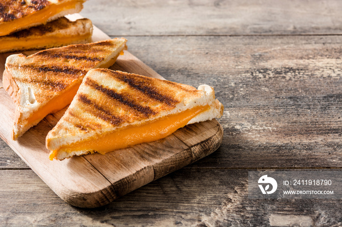 Grilled cheese sandwich on wooden table. Copyspace