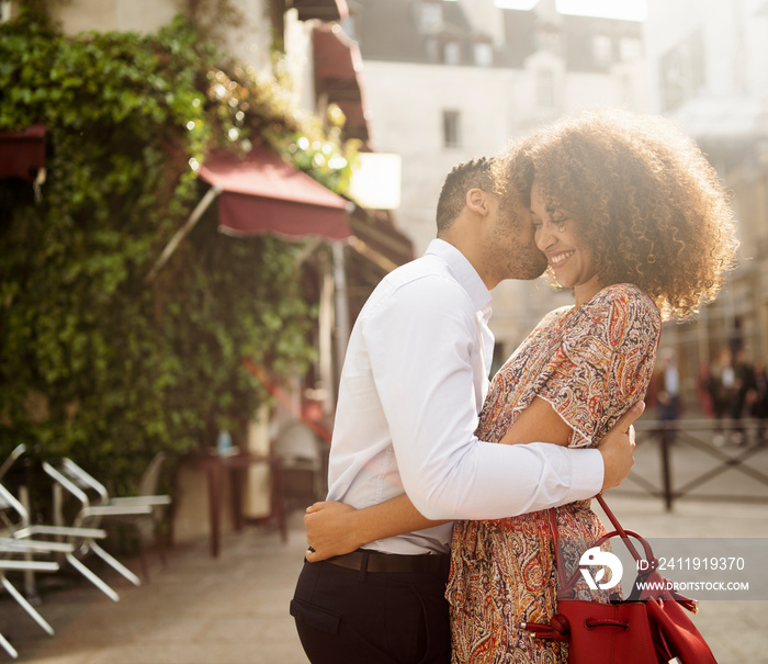 Side view of boyfriend kissing his girlfriend on street