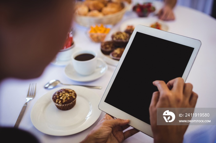 Businesswoman using digital tablet in restaurant