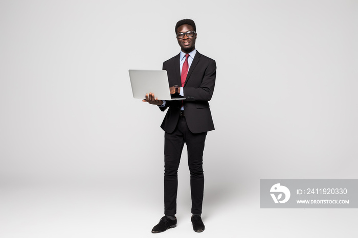 African american young business man with laptop on grey background