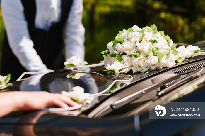 一个人在婚礼当天用鲜花装饰汽车