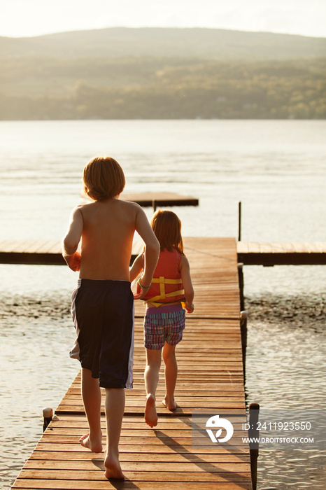 Boy and girl running along jetty