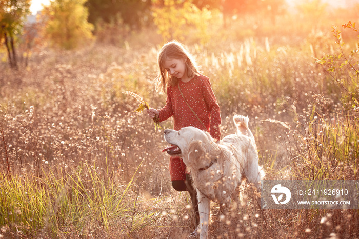 Little girl with dog in autumn nature