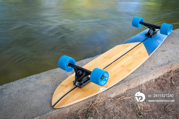 cruising longboard on river shore