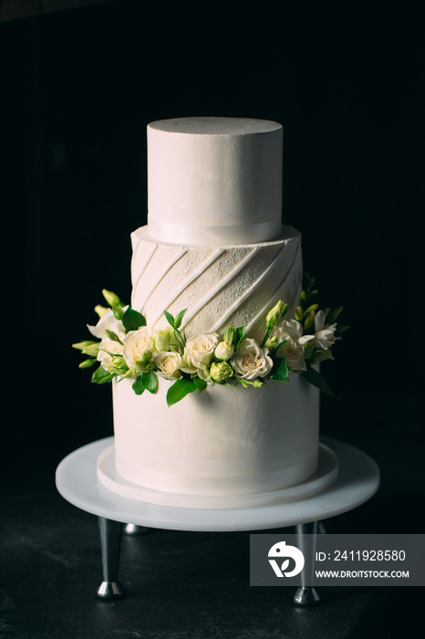 蛋糕在深色背景上装饰着花朵。