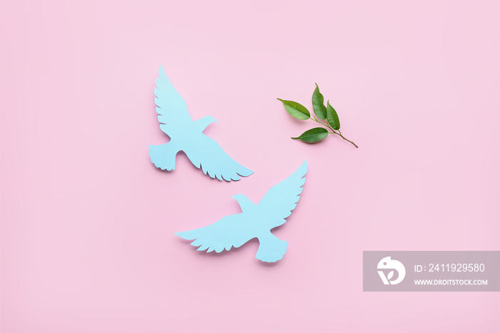 Paper doves and olive branch on color background. International Day of Peace