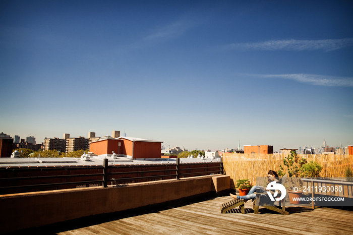 Woman lying on sunlounger on balcony