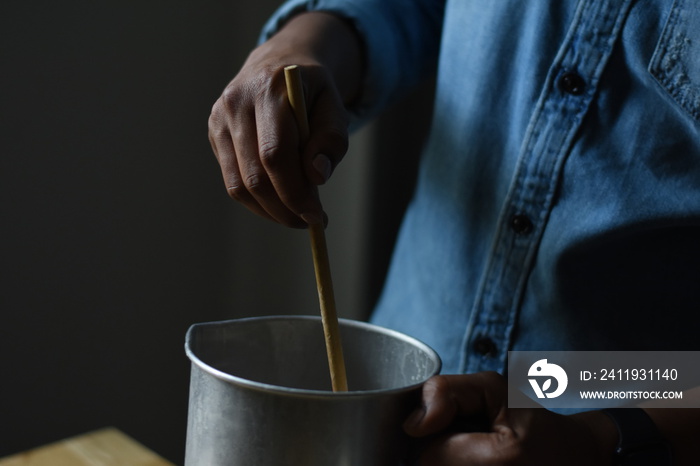 Close-up of man stirring in jug