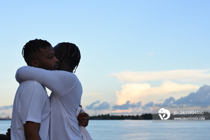 USA, Louisiana, Gay couple embracing against sky