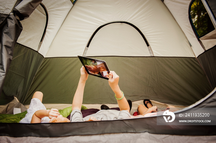 Siblings taking selfie in tent