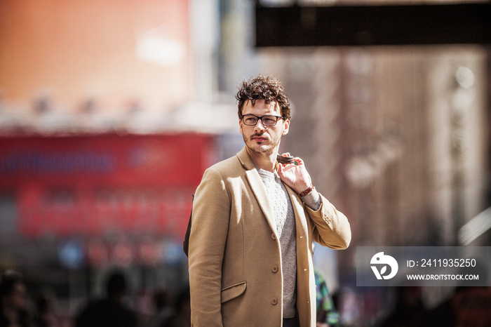 Man standing on street in sunlight