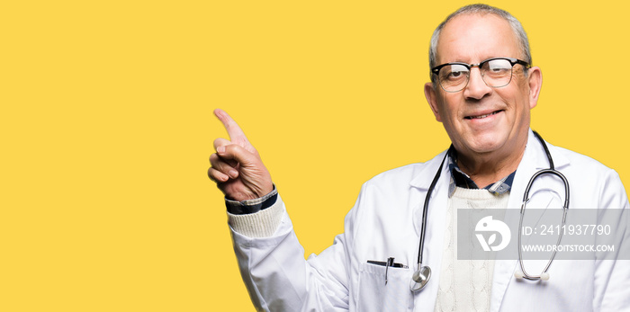 Handsome senior doctor man wearing medical coat with a big smile on face, pointing with hand and fin