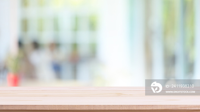 Empty wood table top and blurred of interior restaurant with window view green from tree garden back