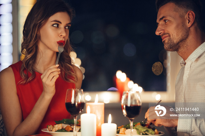 年轻女子在吃浪漫晚餐时与丈夫调情