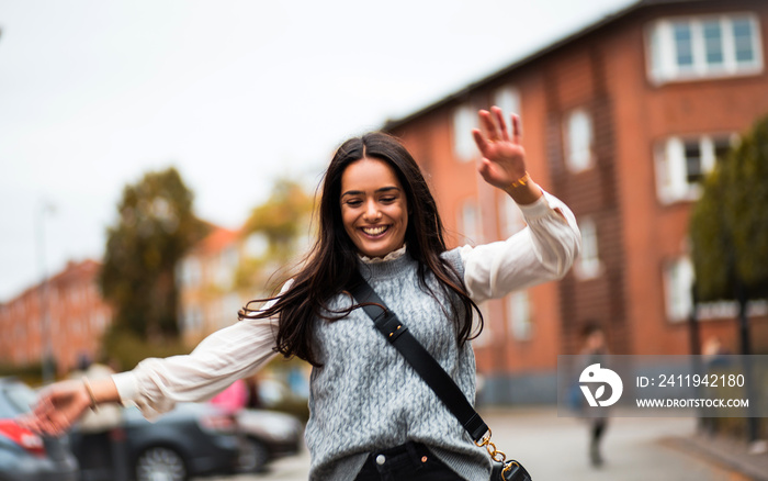 Happy woman dancing on street.