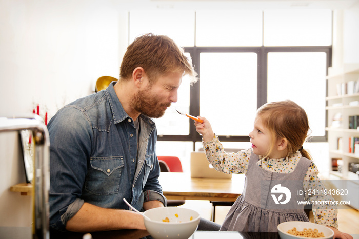 Daughter feeding cereals to her father