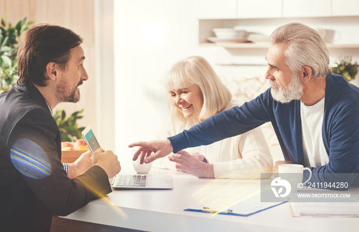 Positive old couple meeting with their insurance agent