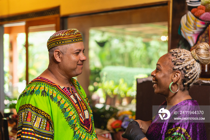 Imagen horizontal de una mujer afrocaribeña hablando alegremente con su esposo en el interior de su 