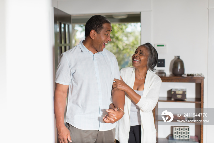 Happy senior couple holding hands at home