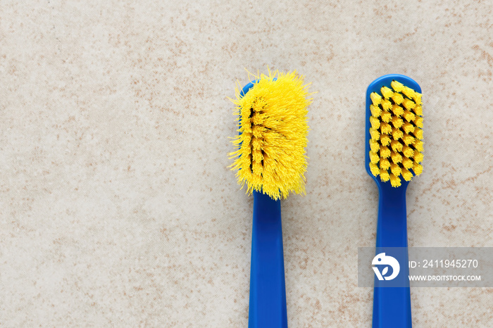 New and worn old toothbrush in contrast on marble background