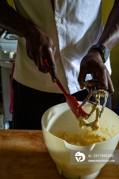 baker cleaning dough from a beater