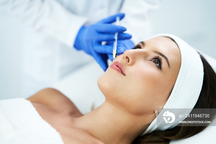 Beautiful young woman getting acid face treatment at beauty salon.