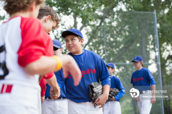 Boys baseball team shaking hands after ball game