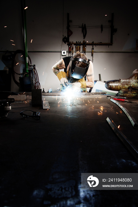 Worker welding in factory