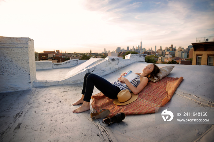 Woman with book lying on rooftop