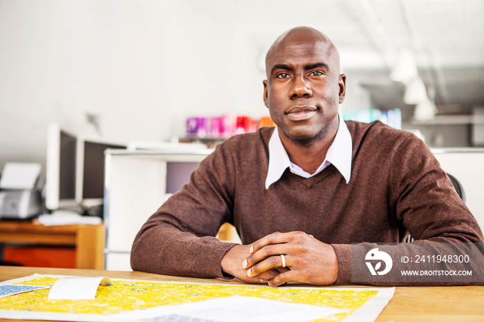 Portrait of man sitting at desk in office