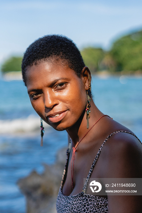 Retrato vertical de una hermosa mujer africana de cabello corto mirando a cámara muy sonriente en la