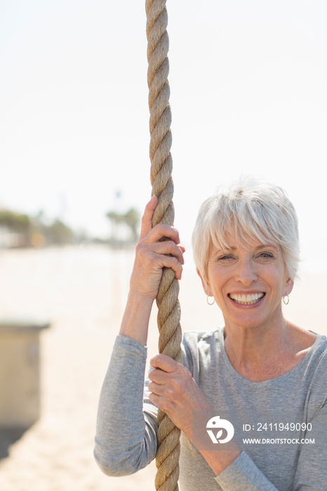 Portrait happy senior woman exercising at rope