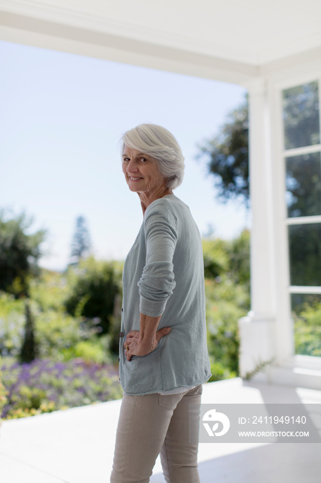 Portrait confident senior woman on sunny patio