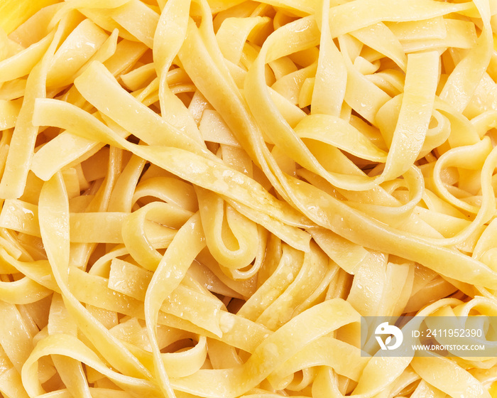 Bunch of italian tagliatelle pasta over yellow background