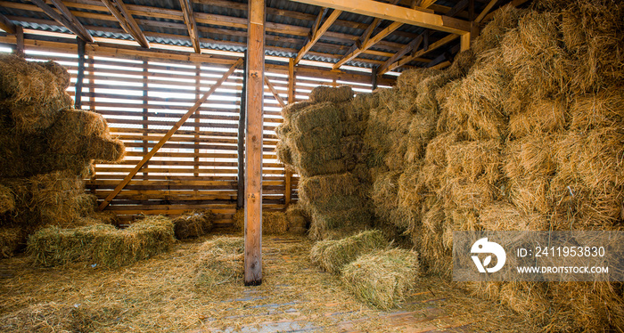 Dry hay stacks in rural wooden barn interior