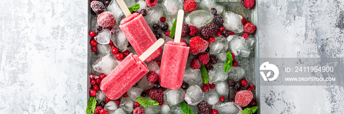 自制草莓冰棍，装在金属板上，配冰块、什锦浆果和薄荷。健康的夏季食物