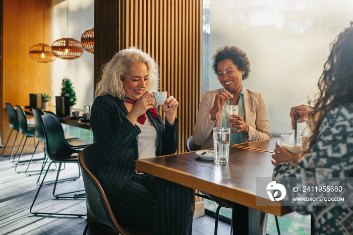 Diverse female friends at cafe drinking coffee