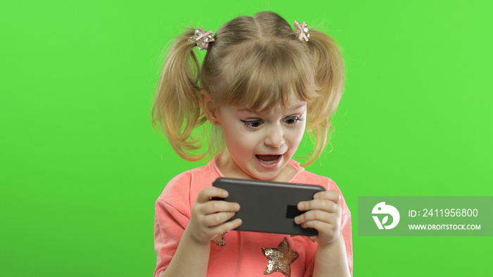 Little girl using smartphone. Portrait of child with smartphone texting, playing