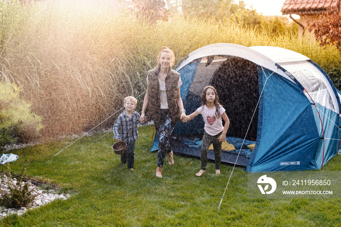 Family having fun camping in their house garden