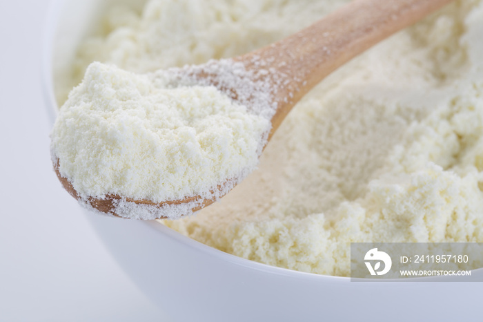 A bowl of milk powder and spoon. Close up.