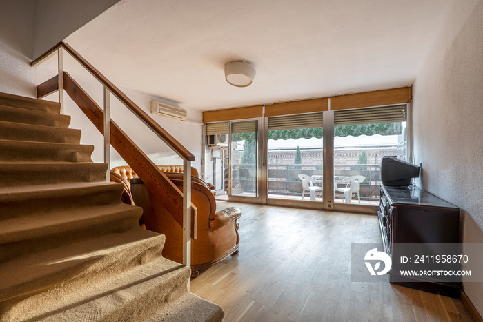 Loft stairs in living room with large window