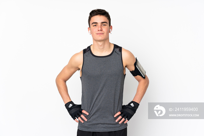 Teenager sport man over isolated white wall posing with arms at hip