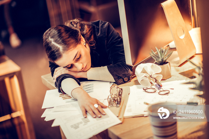 Exhausted young woman putting her head on arm