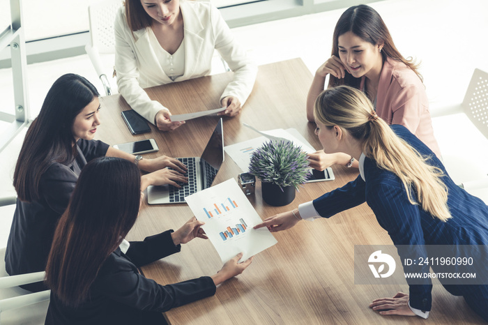 Businesswoman in group meeting discussion with other businesswomen colleagues in modern workplace of