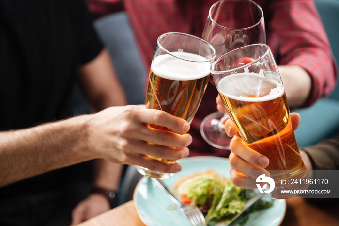 Young friends sitting in cafe while drinking alcohol.