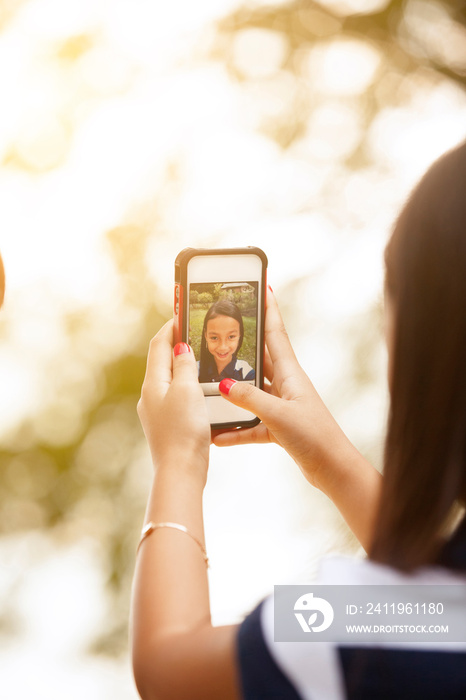 Girl (8-9) taking selfie with smartphone